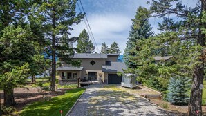 A two-story house with a covered patio, a garage, and a small utility shed. - Alpine Lake House | Beach Access | Hot Tub | Views (Windermere)
