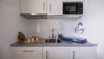 Frigorífico pequeño, microondas, placa de cocina y utensilios de cocina