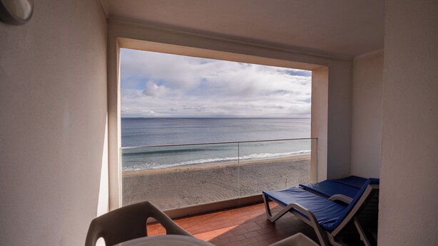 A balcony with a view of the beach and ocean. - Barracuda Hotel (Ponta Delgada)