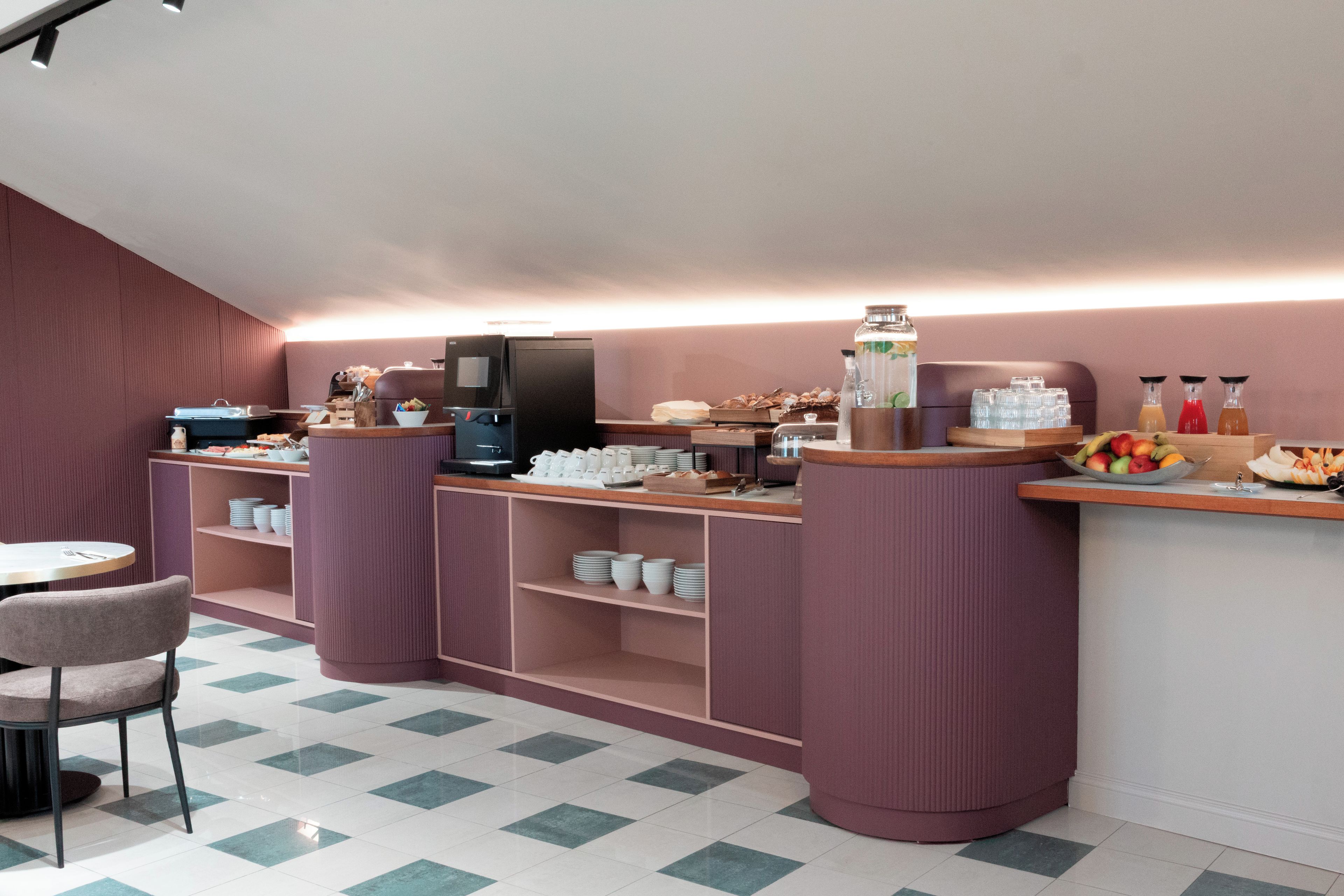 Ein Frühstücksbuffet mit einer Kaffeemaschine, einer Obstschale und verschiedenen Frühstücksangeboten.