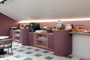 A breakfast bar with a coffee machine, a fruit bowl, and a variety of breakfast items.