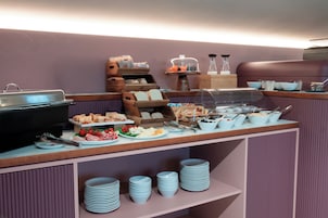 A buffet setup with various food items and serving utensils.
