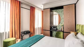A hotel room with a bed, a desk, a chair, and a wardrobe.