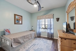 Bedroom with a daybed, wood dresser, TV, and light blue walls. - Golf-front 2BR/2BA Condo on Parkland 17th Hole (Myrtle Beach)