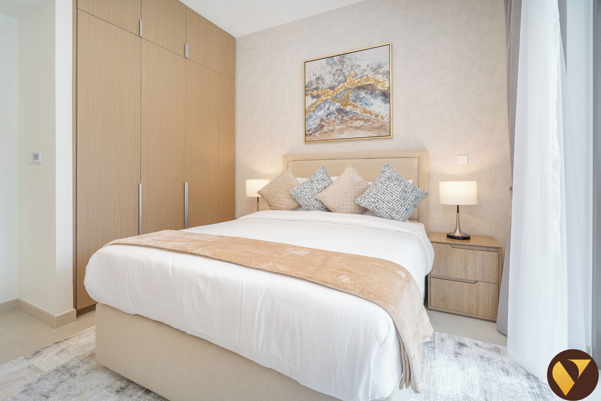 A bedroom with a bed, nightstands, a lamp, a painting, and a wardrobe.