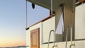 A boat deck with a wooden door, metal ladder, and a view of the water. - Luxurious 2-bedroom Yacht in enchanting Puerto Peñasco with AC (Puerto Peñasco)