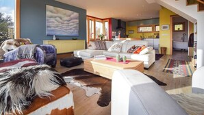 A modern living room with a sofa, coffee table, and a cowhide rug.