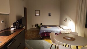 A compact hotel room with a bed, bedside table, and a small kitchenette. - Sonnino Terrace (Pisa)