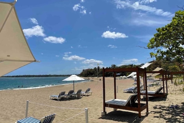 On the beach, white sand, sun-loungers, beach umbrellas