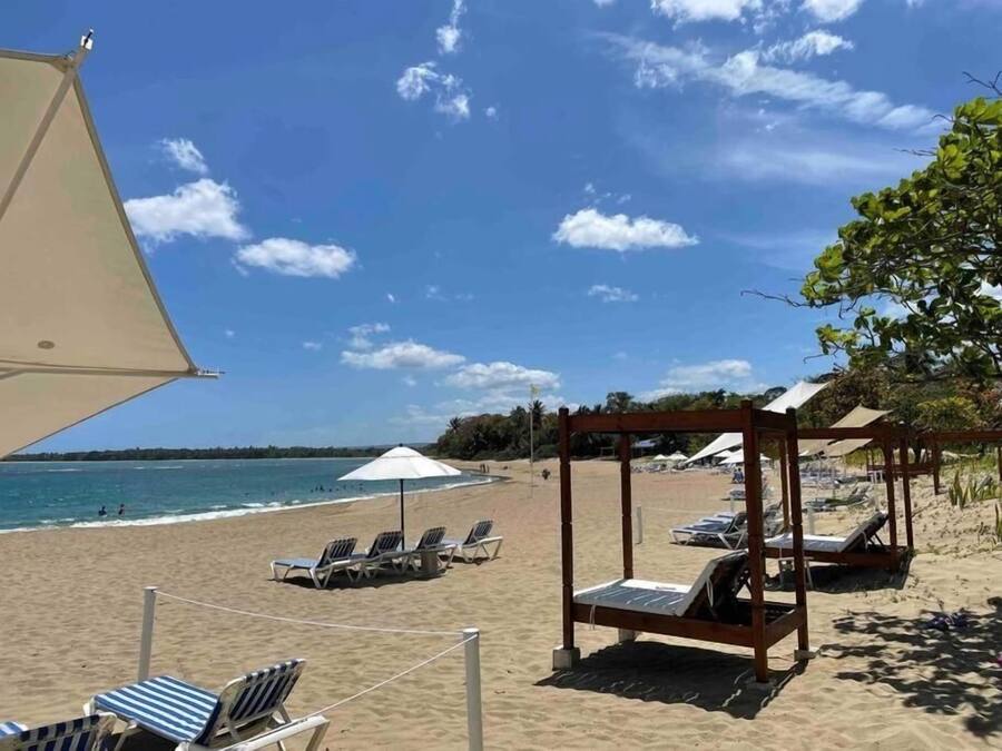 På stranden, hvit sand, solsenger og parasoller