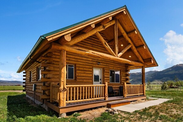 A log cabin with a porch, a door, and windows. - Mountain View Cabin in Pray MT (Pray)