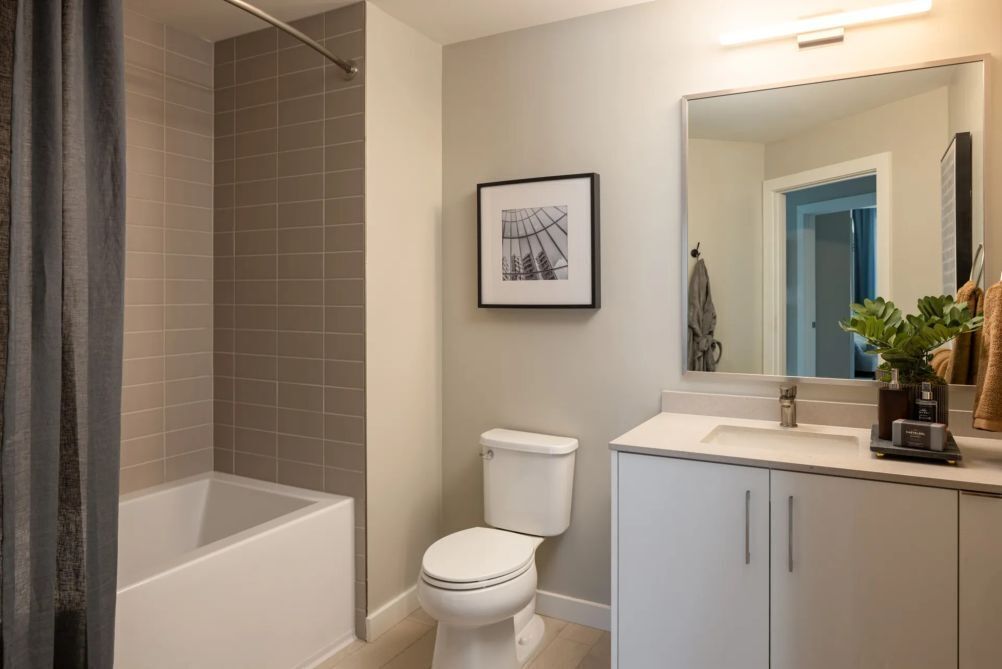 Une salle de bain moderne équipée d’une baignoire, de toilettes et d’un lavabo avec un miroir.