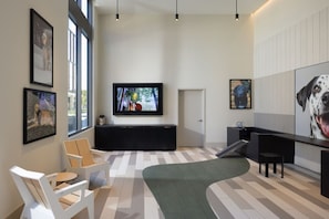 A modern interior with a large TV, artwork, and seating area.