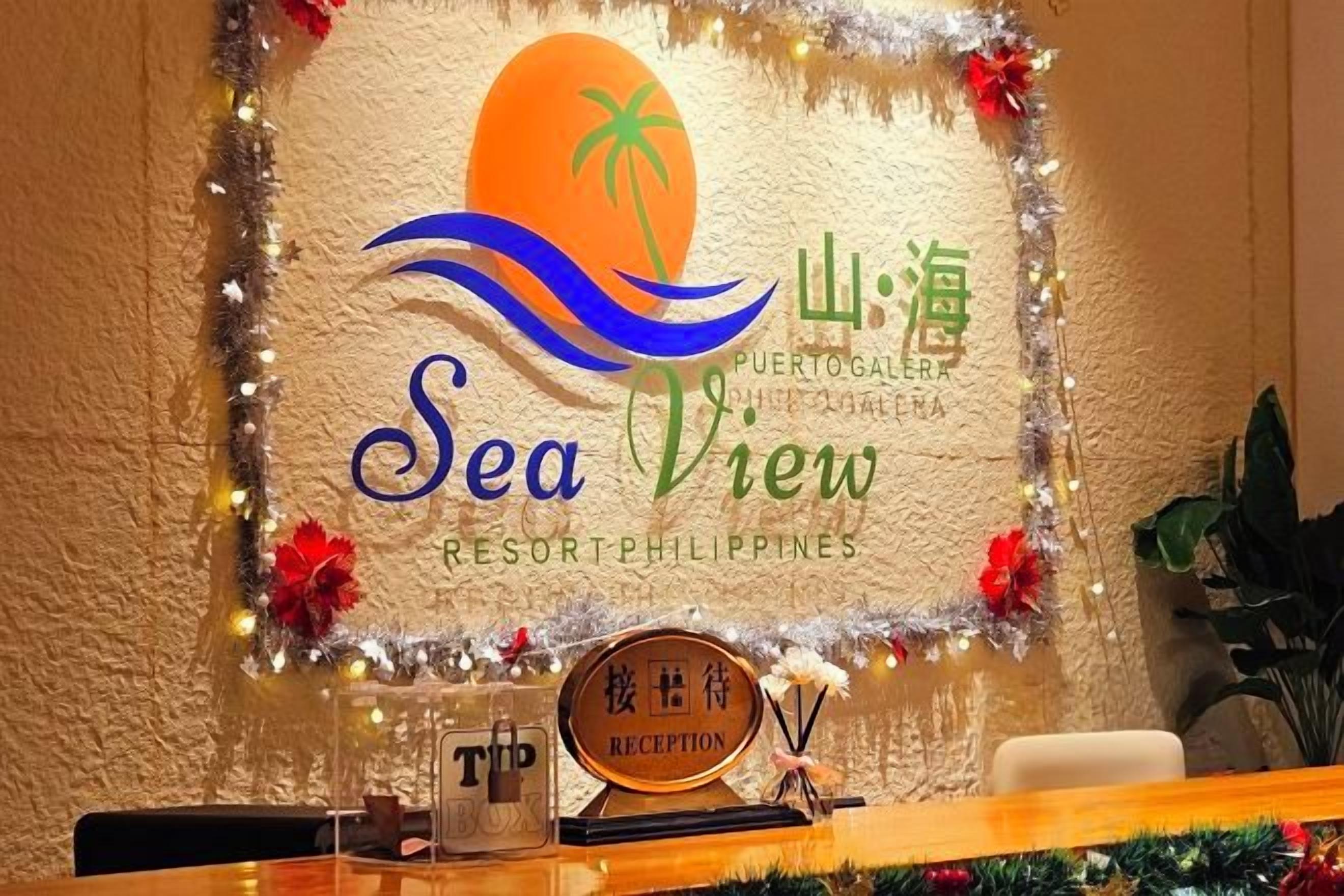 Una recepción con un cartel que indica 'Sea View Resort Philippines' y un logotipo de palmera.