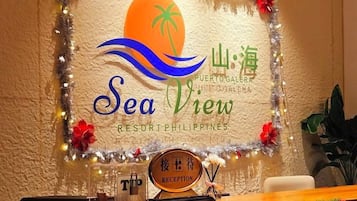 A reception desk with a sign for 'Sea View Resort Philippines' and a palm tree logo.
