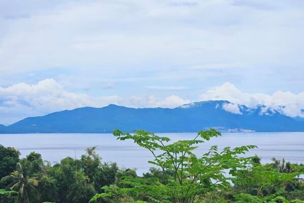 Cordillera montañosa con un cuerpo de agua en primer plano y cielo despejado.