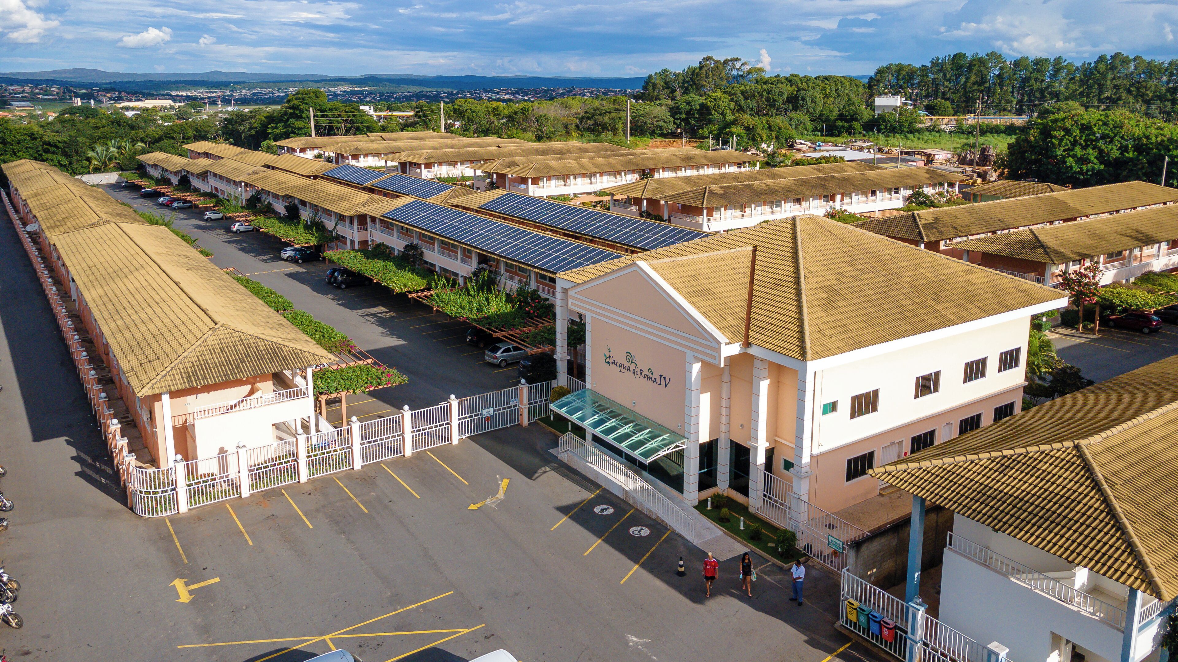 Un hotel con diversi edifici, ognuno dotato di un tetto in tegole e un parcheggio di fronte.