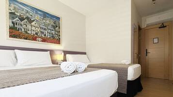 Een hotelkamer met twee bedden, een stadsgezicht op een schilderij en een houten deur.