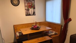 Un coin agréable avec un banc en bois, une petite table et une horloge murale.