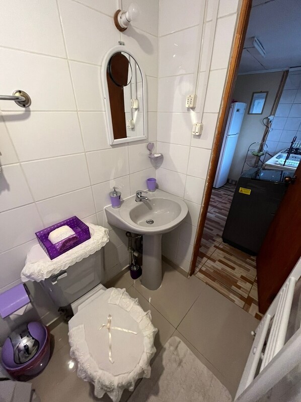 A compact bathroom with a pedestal sink, a toilet, and a bidet. - Cabañas Lupa (Punta Arenas)