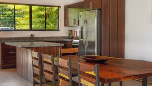 A modern kitchen with a central island, stainless steel appliances, and wooden cabinetry.