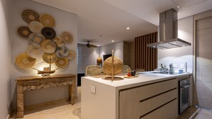 A modern kitchen with a central island, a decorative wall, and a built-in oven.