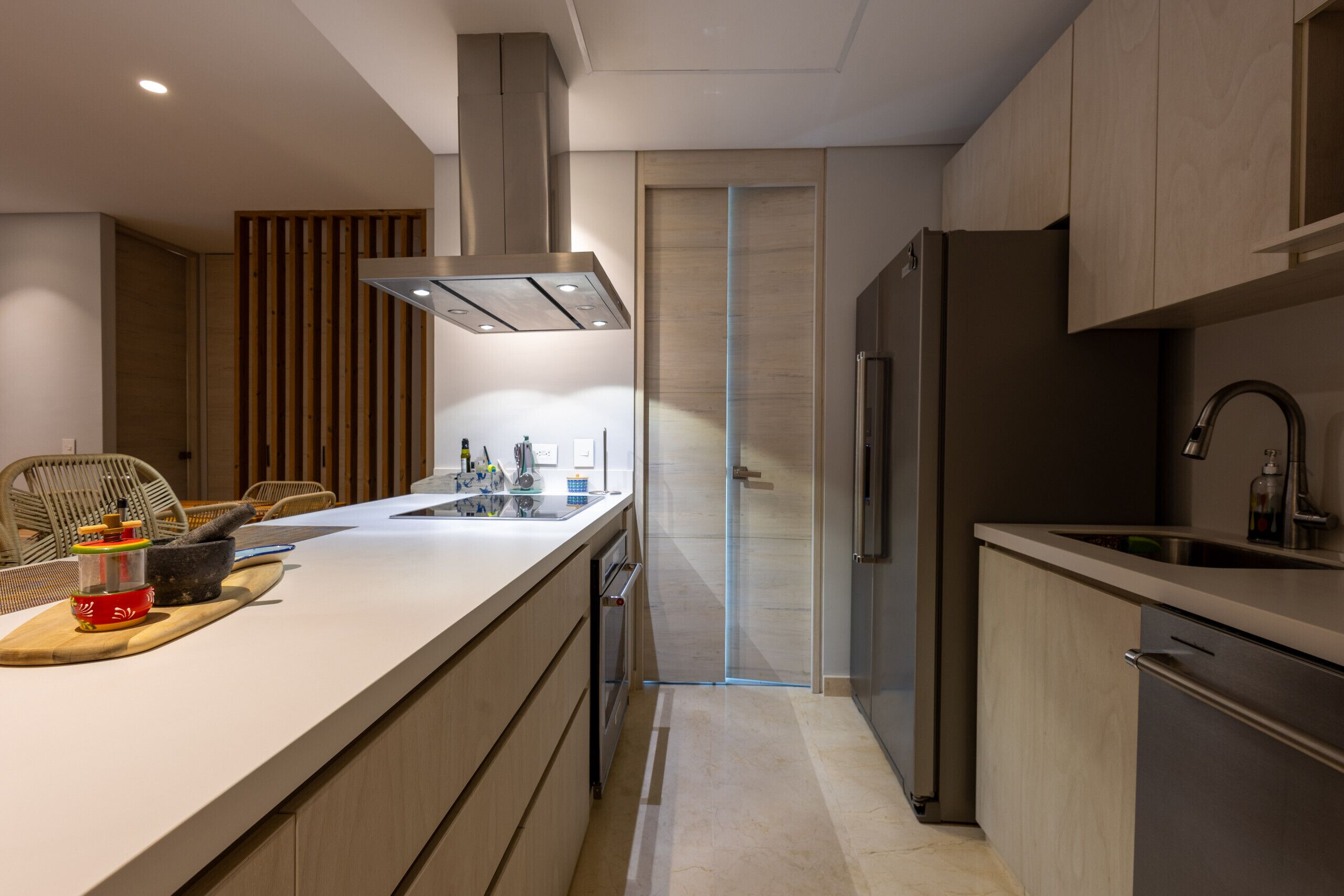 Una cocina moderna con una isla central, electrodomésticos integrados y un diseño elegante.