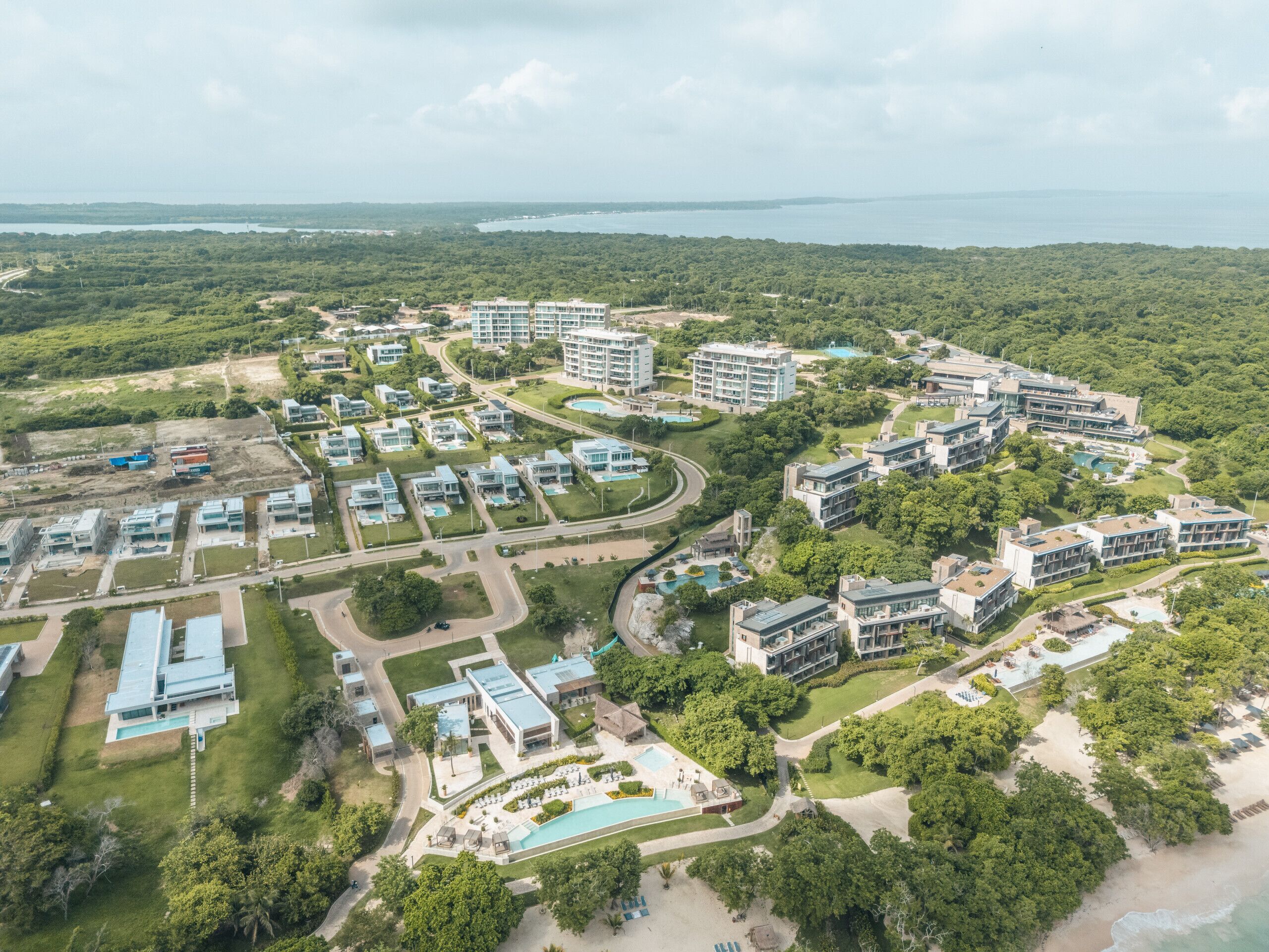 An aerial view of a resort with multiple buildings, roads, and a large pool area.