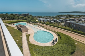 A residential area with multiple swimming pools, a well-maintained lawn, and a view of the sea. - Calablanca T2-405 in Cartagena de Indias (Cartagena)