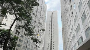 A tall residential building with multiple floors, surrounded by trees and other buildings. - Apartment Bassura City By Berkah Estate By Zuzu (Jakarta)