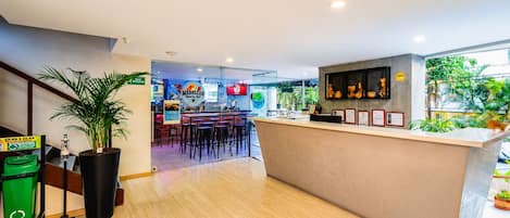 Un bar deportivo con mostrador, taburetes y vistas al exterior.