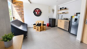 Eine kompakte Küche mit Kühlschrank, Kaffeemaschine und Holzschränken.
