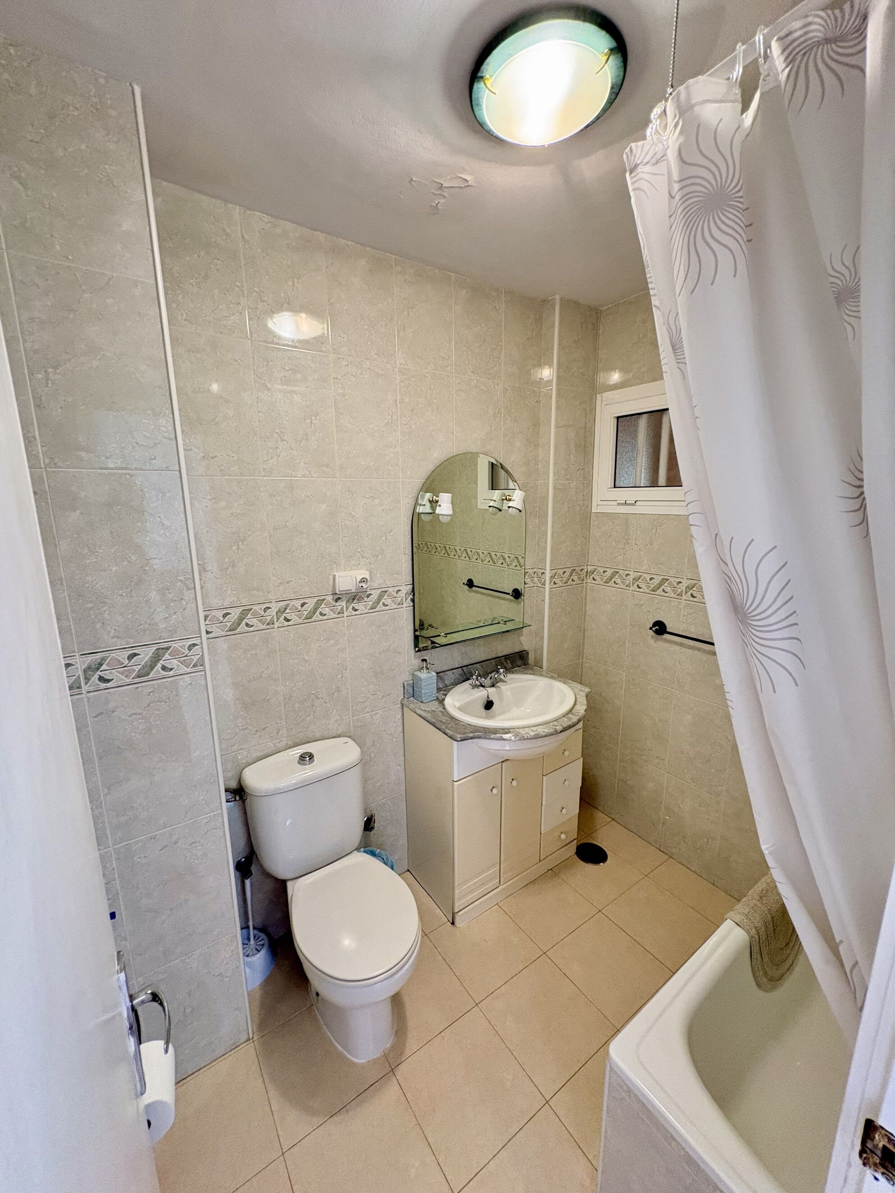 Ein Badezimmer mit Toilette, Waschbecken und Duschvorhang.