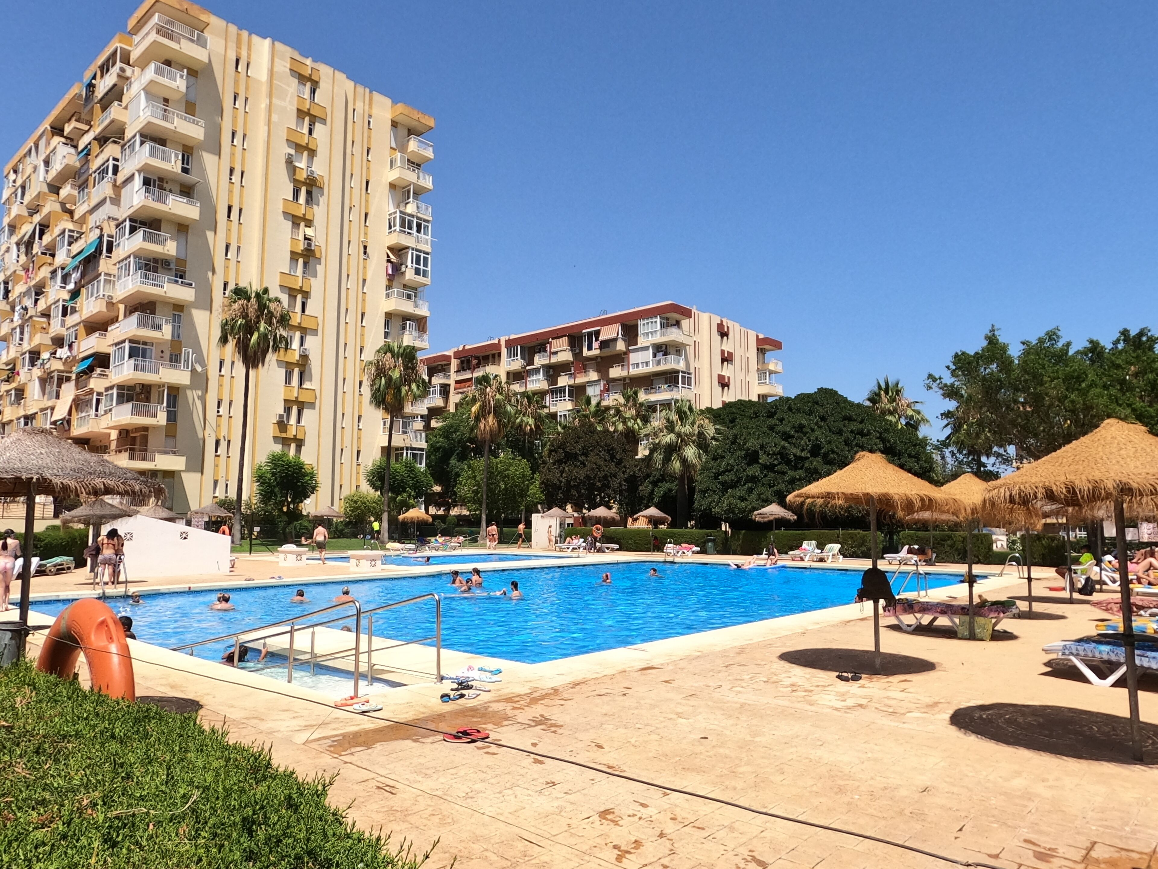 A swimming pool area with a building in the background.