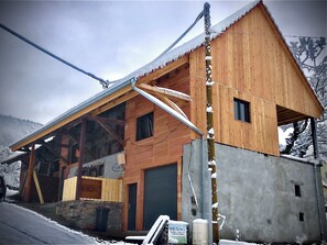 Une cabane en bois avec un toit en pente, une grande fenêtre et des fondations en pierre.