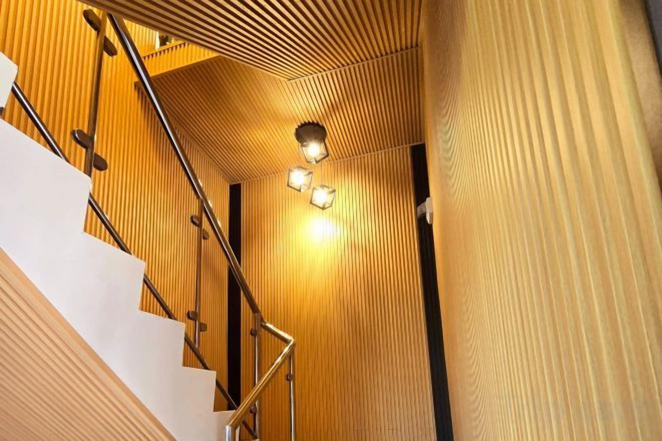 A staircase with wooden paneling and a metal railing.