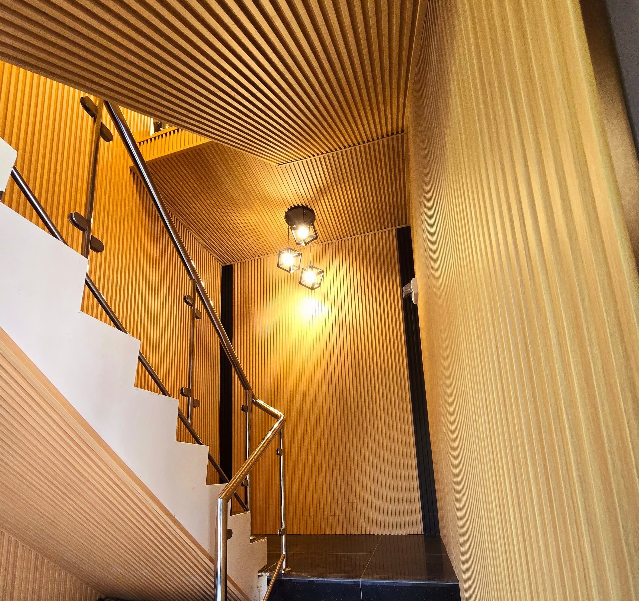 A staircase with wooden paneling and metal railings.