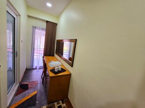 Une chambre d’hôtel avec un bureau en bois, un miroir, une serviette et un plateau avec deux tasses.