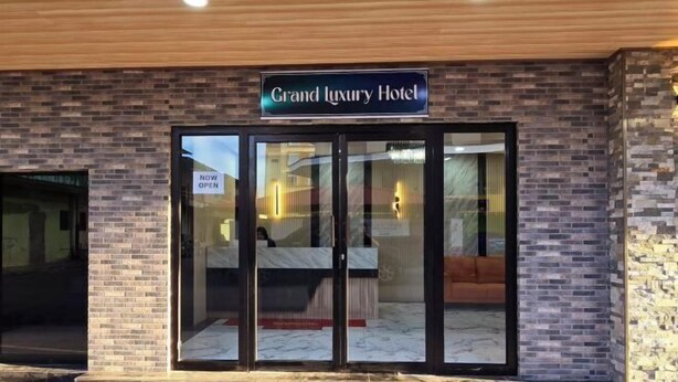 The exterior of a hotel with a sign reading "Grand Luxury Hotel" and a glass door entrance. - Grand Luxury Hotel Semporna (Semporna)