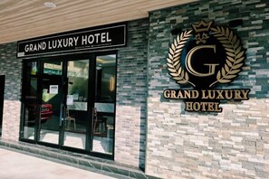 Het uiterlijk van het Grand Luxury Hotel, met een opvallend bord en logo.