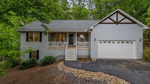 Una casa con veranda, garage e vialetto.