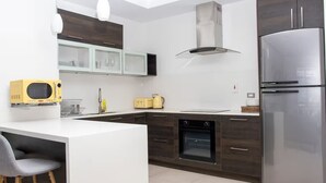 Una cucina moderna con isola centrale, forno a incasso, microonde e frigorifero in acciaio inossidabile.