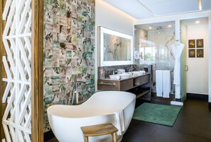 Un baño moderno con una bañera independiente, un tocador con espejo y una zona de ducha.