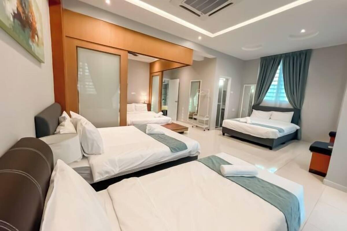 Una habitación de hotel con dos camas, un sofá, un espejo y una ventana con cortinas.