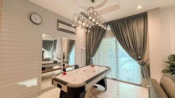 A modern living room with a pool table, a large mirror, and a chandelier.
