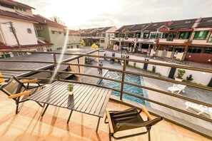 Terraza en la azotea con piscina, mobiliario exterior y vistas de edificios circundantes.
