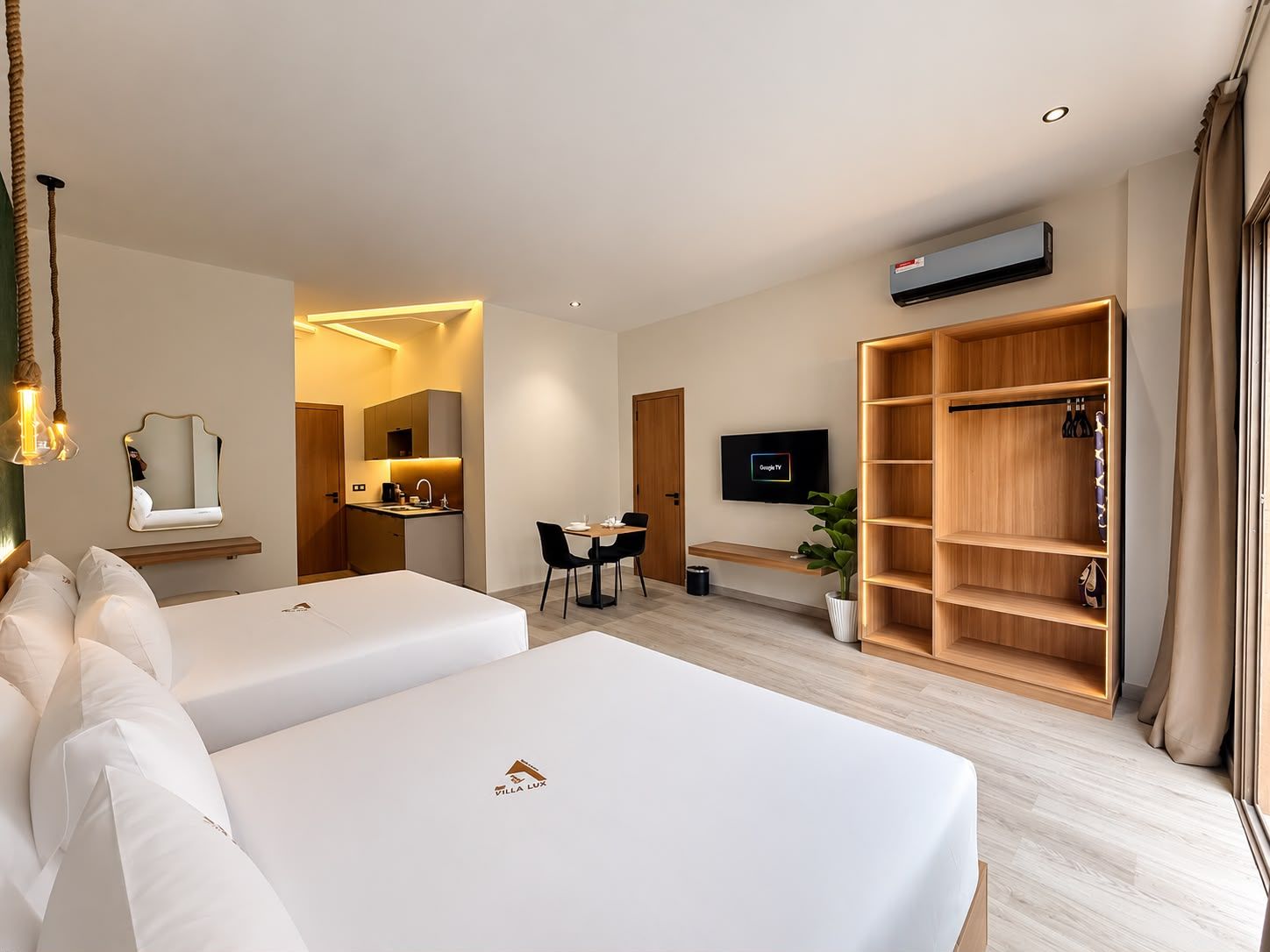 Een hotelkamer met twee bedden, een bureau, een televisie, een kledingkast en een badkamer.