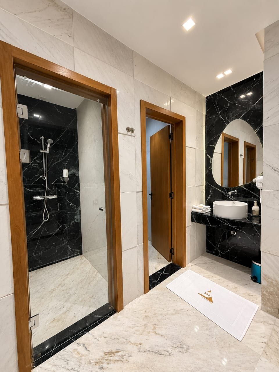 Ein modernes Badezimmer mit Dusche, Waschbecken und Spiegel.
