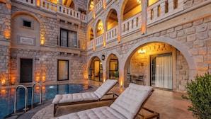 A stone building with a pool, lounge chairs, and a sign reading "Sotto". - Soho Cappadocia (Nevşehir)