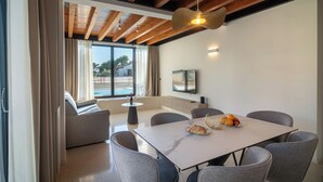Un comedor moderno con una mesa grande, sillas grises y una lámpara colgante.